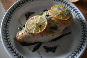 baked chicken breast with lemon and parsley on top